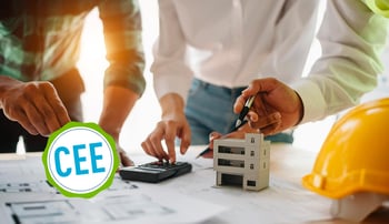 mains-bureau-travaux-compas-calculette-casque-jaune-immeuble-stylo-plans-logo-cee