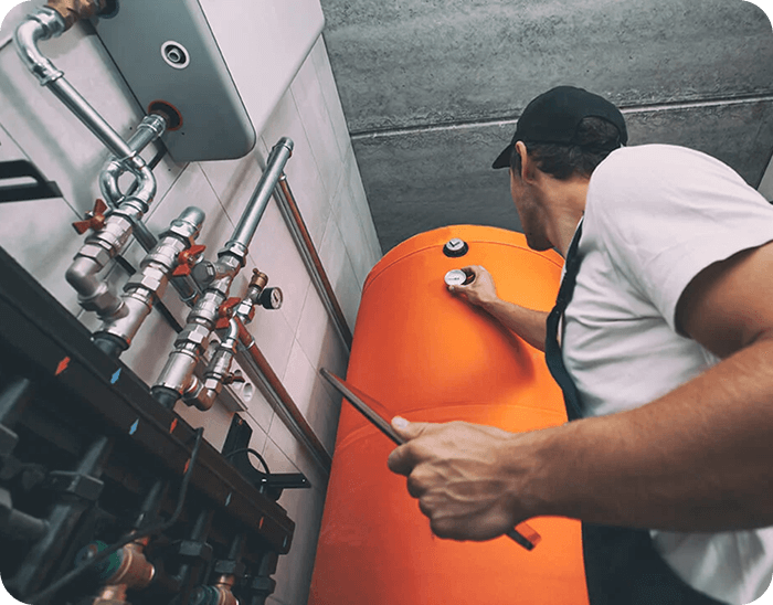 homme casquette verifie ballon eau chaude orange chauffage